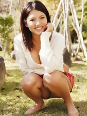 Anri Sakura posing in red skirt and white shirt outdoors