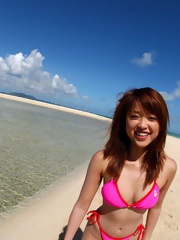 Asian babe Asuka enjoys sunning and playing naked on the beach